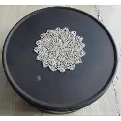 Groot rond verweerd blik met gehaakt kleedje